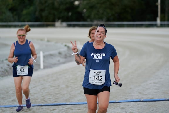 Eine Teilnehmerin macht ein Peace-Zeichen und läuft beim POWER RUN.