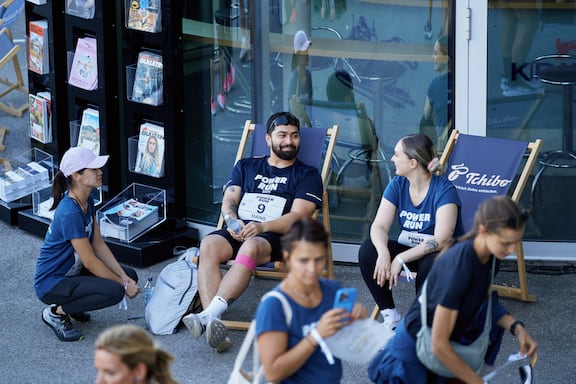 Teilnehmerinnen und Teilnehmer de POWER RUN sitzen auf Liegestühlen unter unterhalten sich.