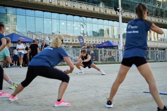 Fabian von Shaped by iB macht Aufwärmübungen mit den Teilnehmenden des POWER RUN.