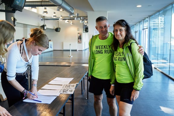 Ein Mann und eine Frau stehen bei der Startnummernausgabe des POWER RUN.