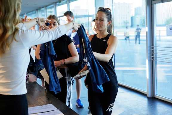 Eine Frau holt sich ihr Funktionsshirt für den POWER RUN ab.