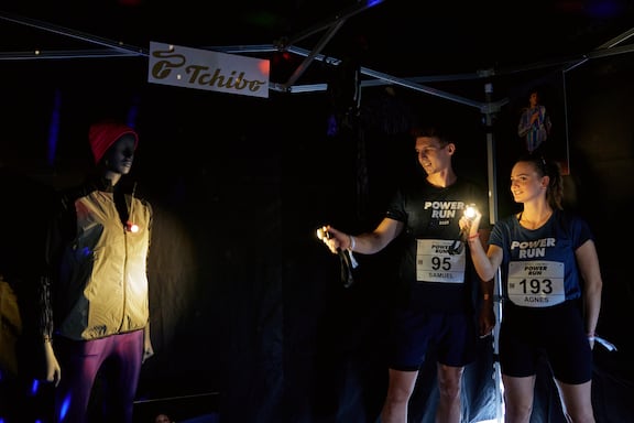 In einem verdunkelten Zelt, wird die neue Laufsport-Kollektion von Tchibo vorgestellt.