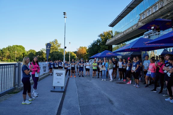Alina Marzi und eine Miterabeiterin von Tchibo moderieren den POWER RUN. Die Teilnehmerinnen und Teilnehmer hören gespannt zu.