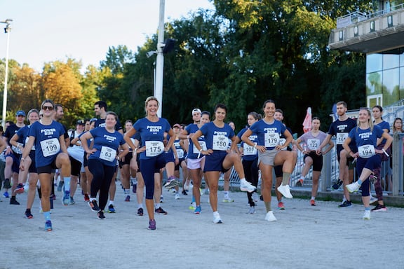 Teilnehmerinnen und Teilnehmer des POWER RUN wärmen sich für den POWER RUN auf.