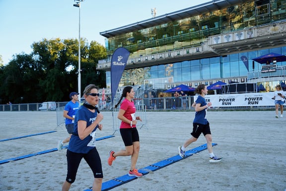 Teilnehmerinnen und Teilnehmer des POWER RUN beim Laufen über die Ziellinie.