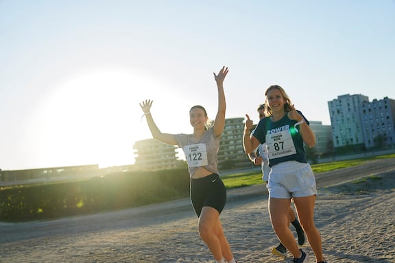 Drei Teilnehmerinnen des POWER RUN lächeln in die Kamera.