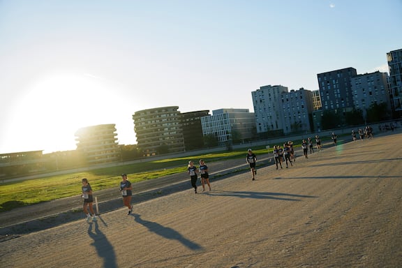 Teilnehmerinnen und Teilnehmer des POWER RUN beim Laufen auf der Trabrennbahn in Wien.
