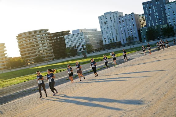 Teilnehmerinnen und Teilnehmer des POWER RUN beim Laufen auf der Trabrennbahn in Wien.