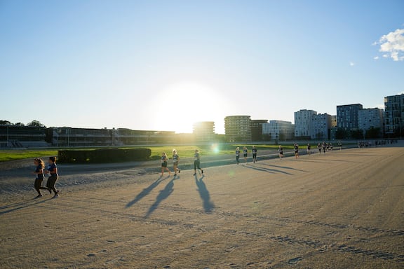 Teilnehmerinnen und Teilnehmer des POWER RUN beim Laufen auf der Trabrennbahn in Wien.