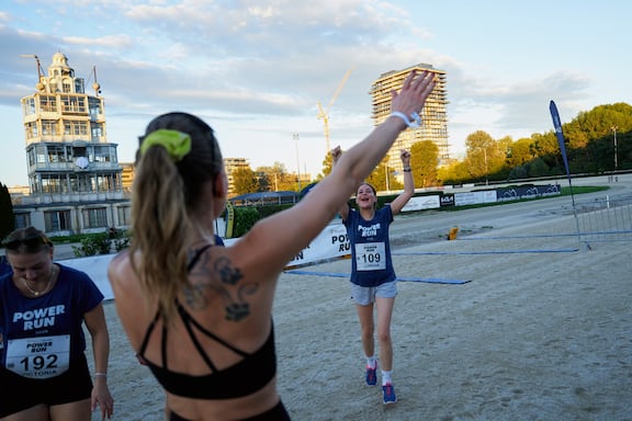 Eine Teilnehmer hebt in die Hände in die Höhe und freut sich nach dem Zieleinlauf des POWER RUN.