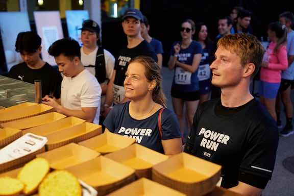 Teilnehmerinnen und Teilnehmer bestellen sich beim Foodtruck etwas zum Essen