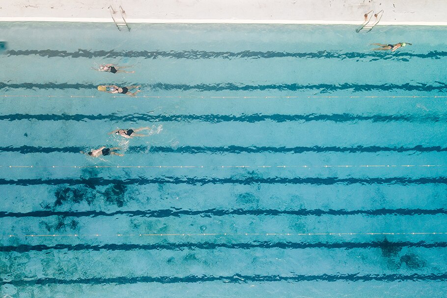 Menschen schwimmen im Schwimmbad Bahnen